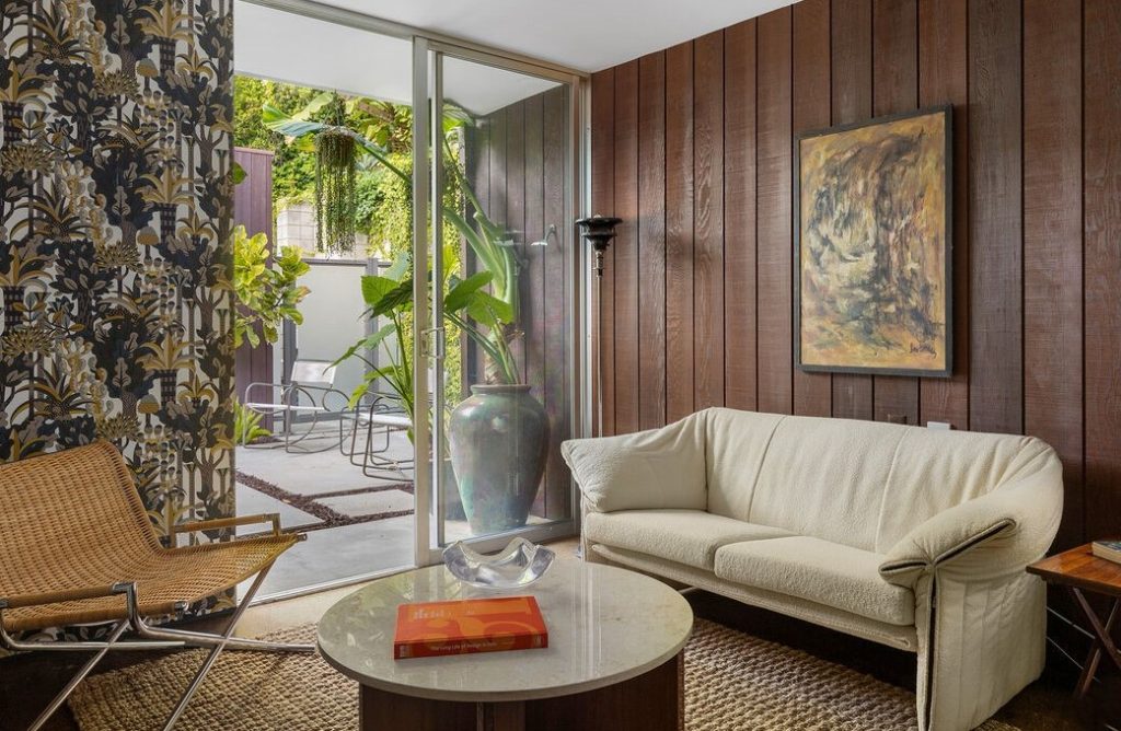 this three-bedroom (2 bed + office) home showcases original features including striking floor-to-ceiling windows that offer an abundance of natural light, warm wood-paneled walls
