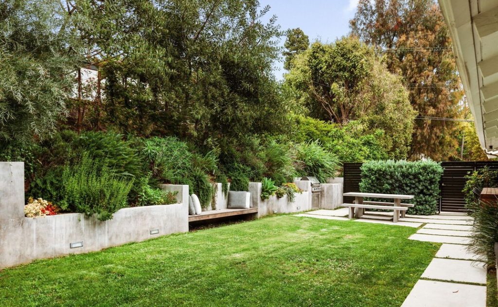 the spacious grassy yard - which features built-in seating, serving counter and BBQ - and adjacent jasmine filled atrium