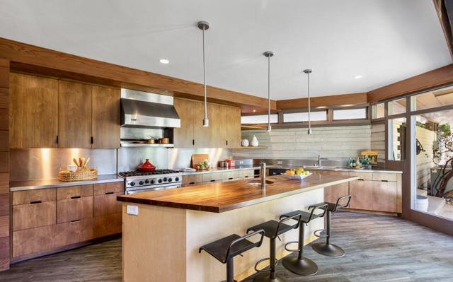 The open floor plan, with its unique shapes and oblique angles, is thoughtfully arranged into three distinct zones: the living space, kitchen-dining area, and the bedroom wing