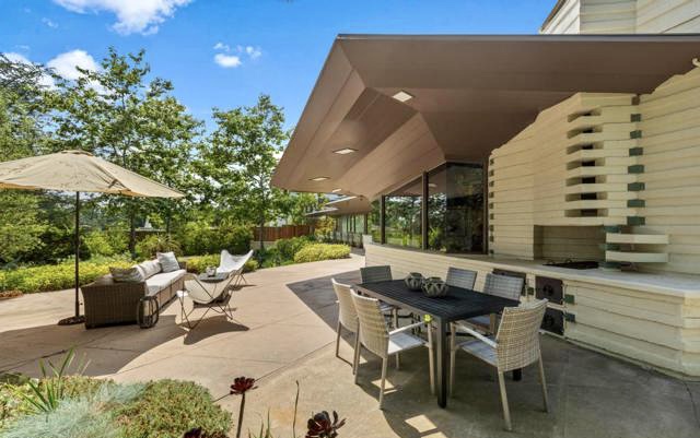 The open floor plan, with its unique shapes and oblique angles, is thoughtfully arranged into three distinct zones: the living space, kitchen-dining area, and the bedroom wing