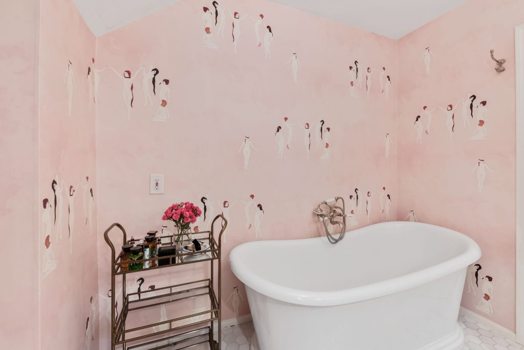 A custom designed bathroom featuring a rose quartz vanity is truly spectacular. The elegant wallpaper by Maison C was designed specifically for this primary bathroom.